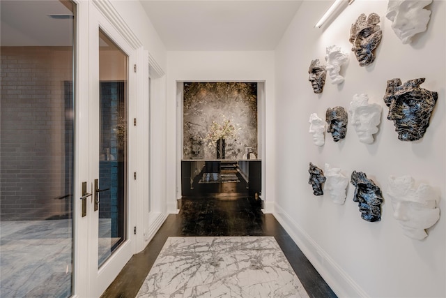 hall featuring baseboards and dark wood finished floors