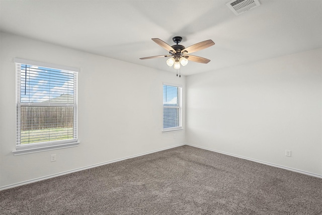 carpeted spare room featuring visible vents, baseboards, and a ceiling fan