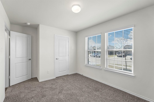 unfurnished bedroom with baseboards and carpet