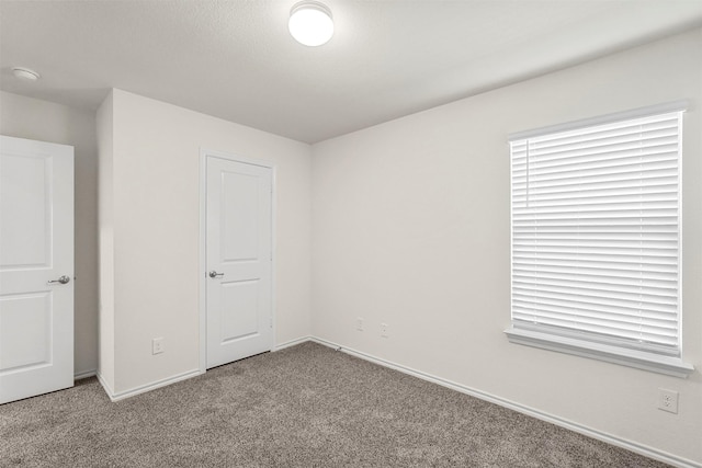 unfurnished bedroom with carpet flooring and baseboards