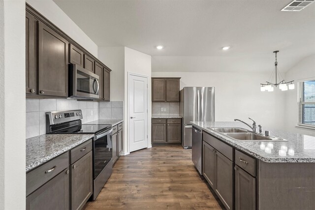 kitchen with visible vents, a sink, stainless steel appliances, dark brown cabinetry, and dark wood-style flooring