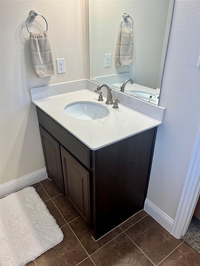 bathroom with tile patterned flooring, vanity, and baseboards