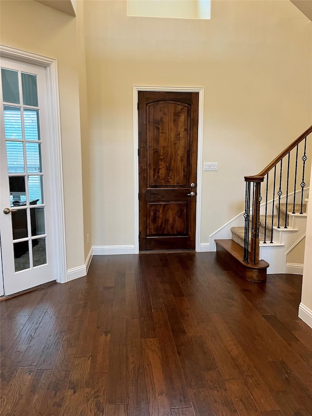 foyer entrance featuring stairs, hardwood / wood-style flooring, and baseboards