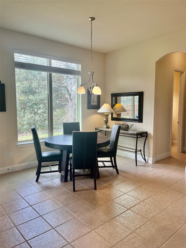 dining room featuring baseboards and arched walkways