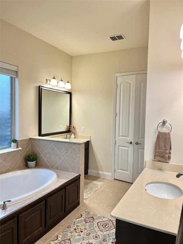 bathroom with a bath, visible vents, tile patterned floors, and vanity