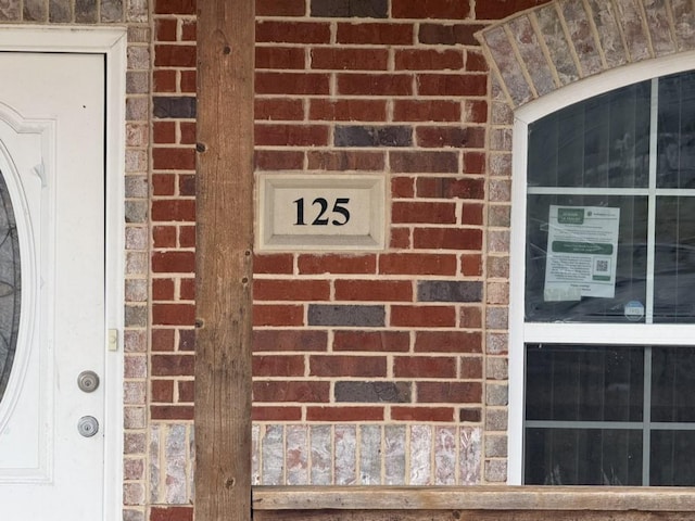 view of exterior entry with brick siding