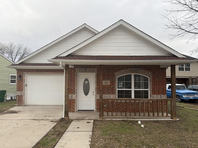 view of front of home with driveway, covered porch, a shingled roof, a garage, and brick siding