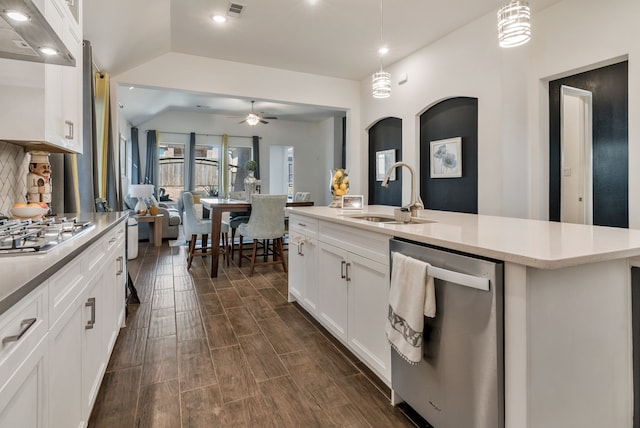 kitchen featuring a sink, open floor plan, appliances with stainless steel finishes, wood tiled floor, and hanging light fixtures