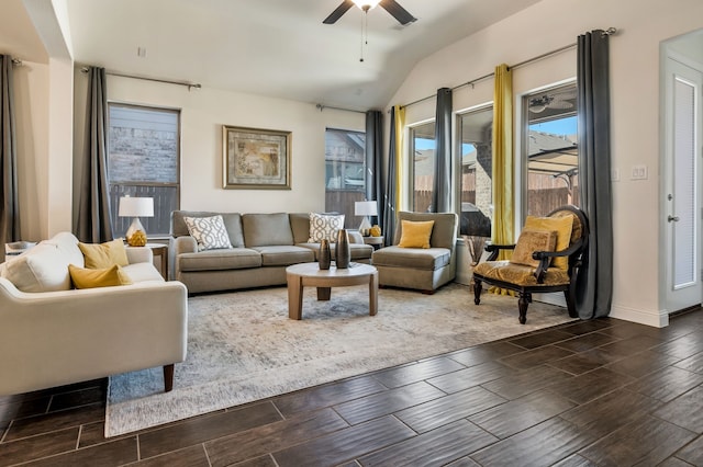 living area with baseboards, a ceiling fan, lofted ceiling, and wood finish floors