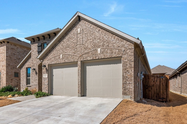 view of front facade with brick siding, an attached garage, and driveway