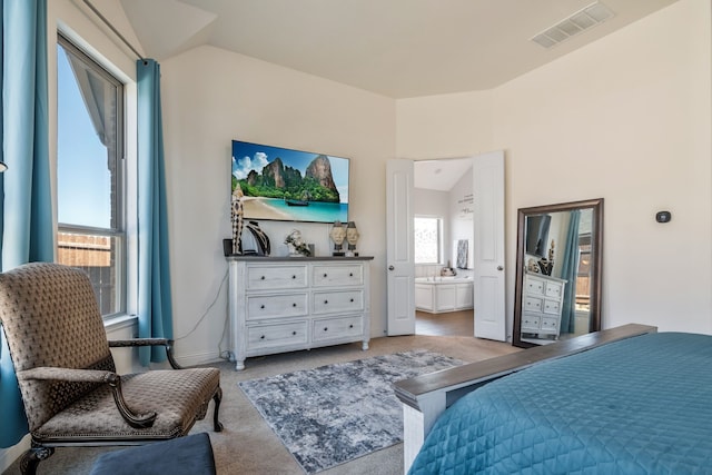 bedroom featuring visible vents, light carpet, ensuite bath, baseboards, and vaulted ceiling