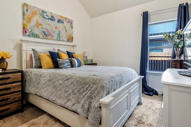 bedroom with lofted ceiling and light carpet