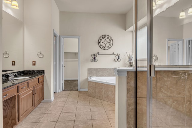 bathroom with tile patterned flooring, a walk in closet, a stall shower, a bath, and vanity