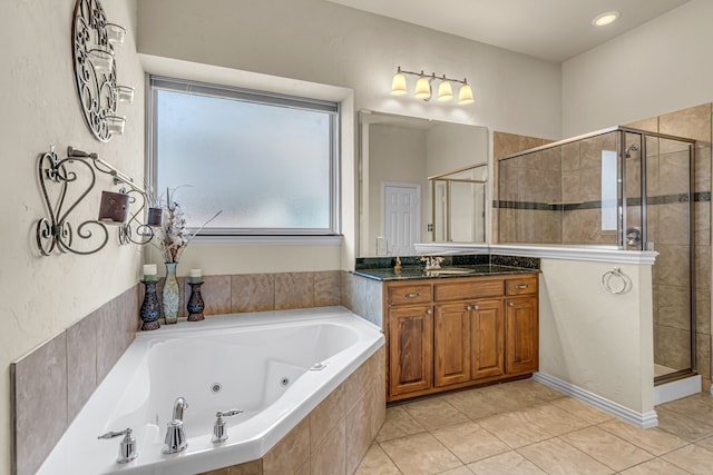 bathroom featuring tile patterned flooring, a stall shower, a jetted tub, and vanity