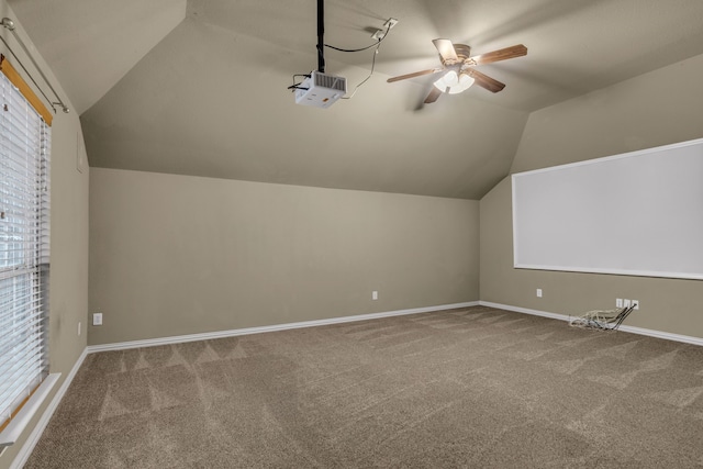 additional living space with baseboards, carpet floors, ceiling fan, and vaulted ceiling