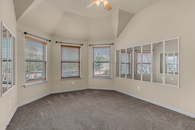 carpeted spare room with baseboards, a healthy amount of sunlight, a ceiling fan, and lofted ceiling