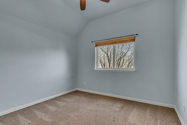 carpeted spare room featuring baseboards, lofted ceiling, and ceiling fan