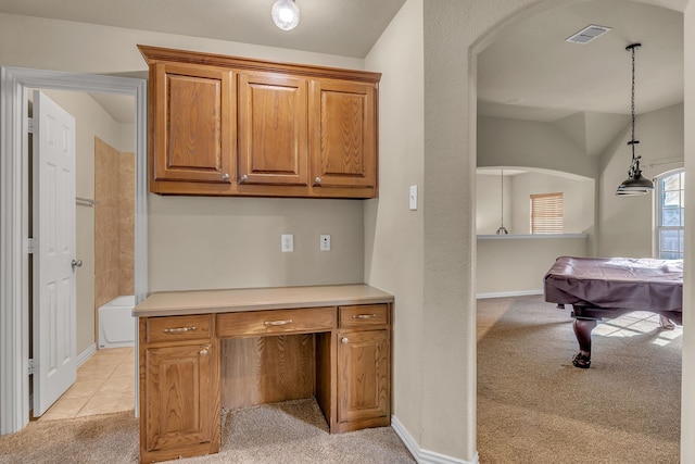 kitchen with visible vents, light colored carpet, pendant lighting, light countertops, and brown cabinets