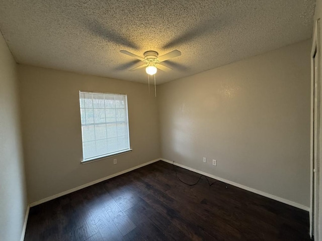 unfurnished room with a textured ceiling, dark wood-style floors, baseboards, and ceiling fan