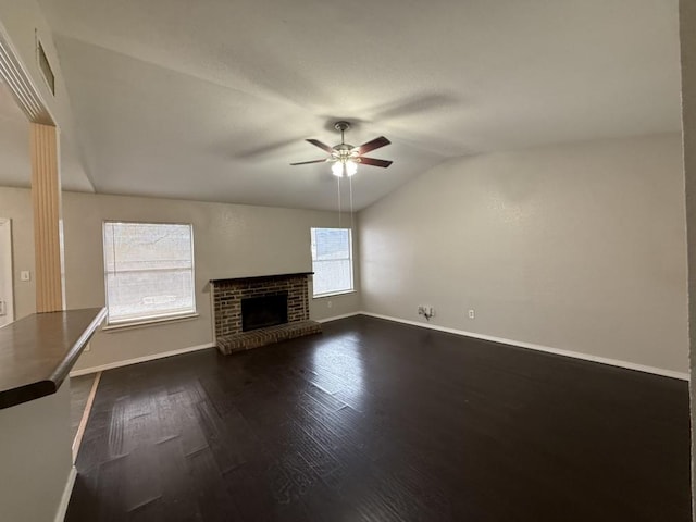 unfurnished living room with lofted ceiling, dark wood-style floors, a fireplace, baseboards, and ceiling fan