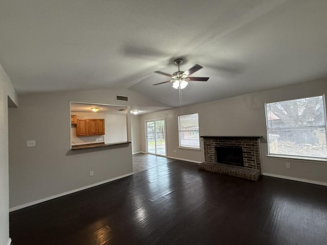 unfurnished living room with visible vents, a brick fireplace, baseboards, dark wood finished floors, and vaulted ceiling