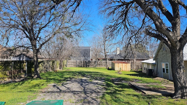 view of yard with an outbuilding, central AC, and fence private yard