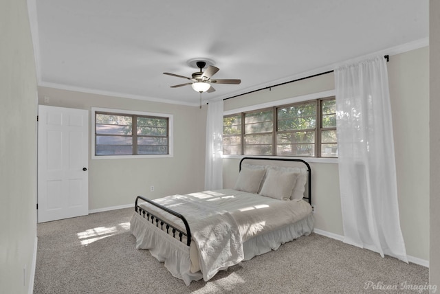 bedroom featuring crown molding, carpet flooring, baseboards, and ceiling fan