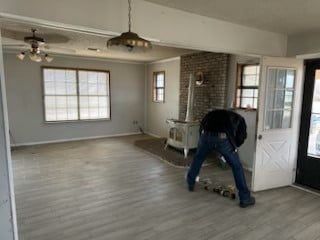 foyer with a wood stove, wood finished floors, and baseboards