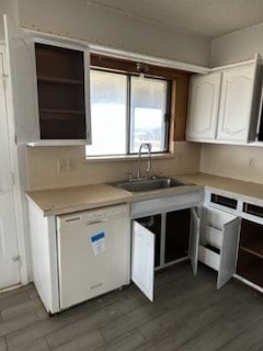 kitchen featuring open shelves, white dishwasher, light countertops, white cabinets, and dark wood-type flooring