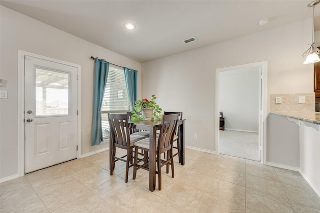 dining space with light tile patterned floors, visible vents, and baseboards