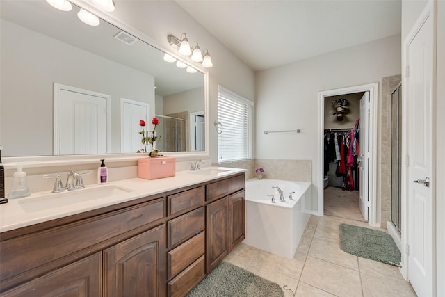 bathroom with tile patterned floors, visible vents, a shower stall, and a sink