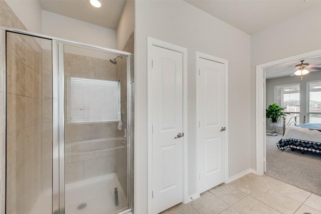 ensuite bathroom with tile patterned flooring, a shower stall, baseboards, ensuite bathroom, and a ceiling fan