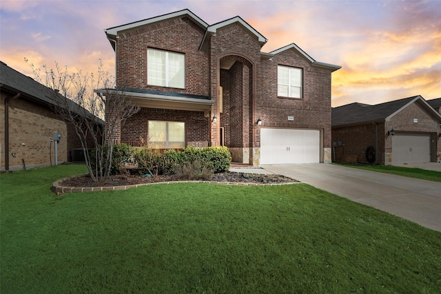 traditional-style house featuring an attached garage, a lawn, brick siding, and driveway