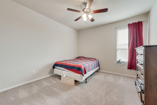 carpeted bedroom with ceiling fan and baseboards