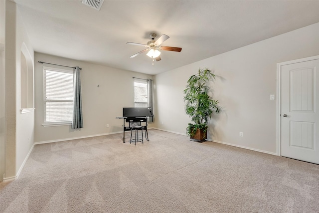 unfurnished office with baseboards, visible vents, a ceiling fan, and carpet