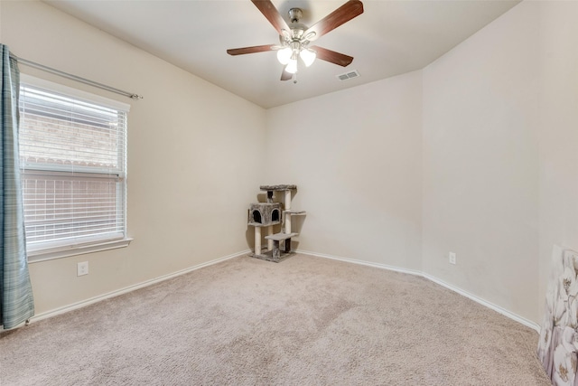 carpeted spare room featuring visible vents, ceiling fan, and baseboards