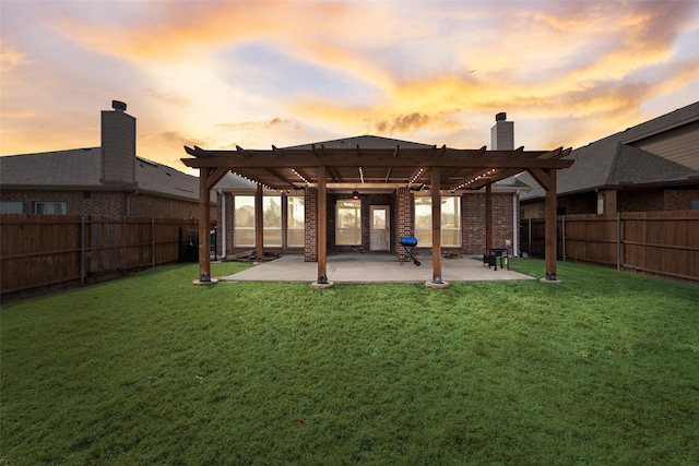 back of house at dusk with a lawn, a fenced backyard, and a pergola