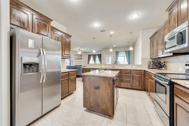 kitchen featuring tasteful backsplash, visible vents, a peninsula, light tile patterned flooring, and stainless steel appliances