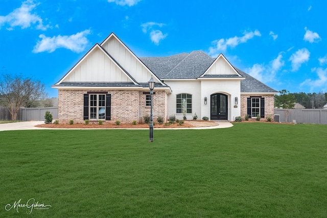 view of front of property with a front yard, fence, and brick siding