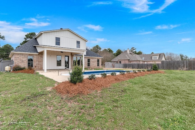 back of property with a patio, a ceiling fan, a fenced backyard, a lawn, and brick siding