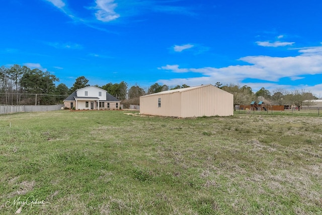 view of yard featuring an outbuilding and fence