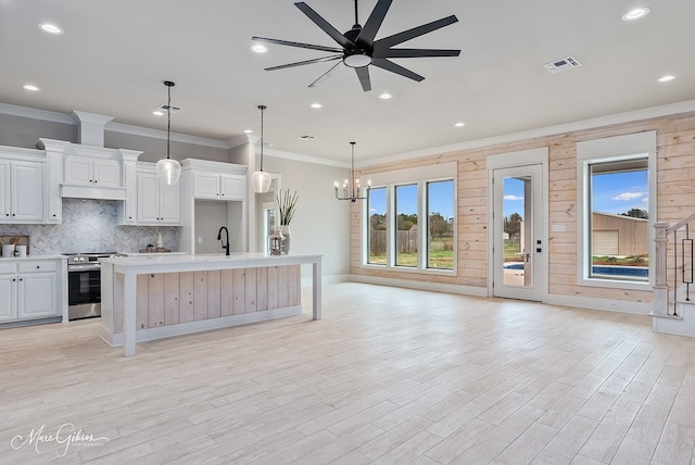 kitchen featuring visible vents, backsplash, open floor plan, light countertops, and stainless steel range with electric stovetop