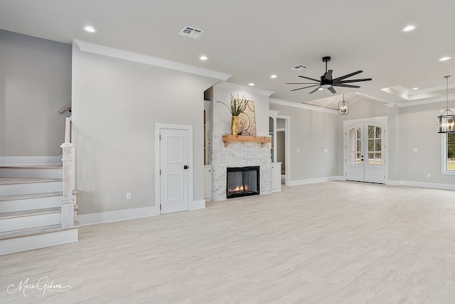 unfurnished living room featuring baseboards, light wood-type flooring, stairs, ornamental molding, and ceiling fan with notable chandelier