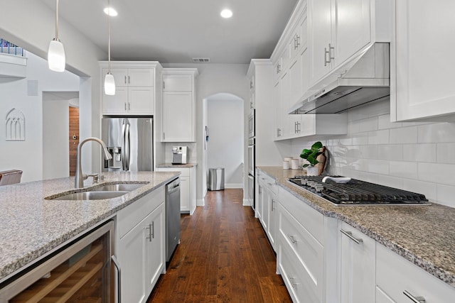 kitchen with visible vents, under cabinet range hood, beverage cooler, appliances with stainless steel finishes, and a sink