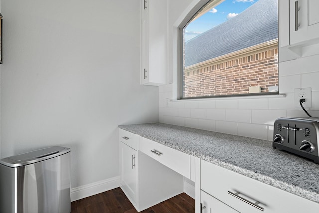 interior space featuring a toaster, baseboards, and dark wood-style flooring