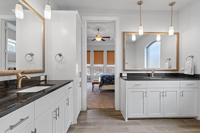 ensuite bathroom featuring a healthy amount of sunlight, ceiling fan, and a sink