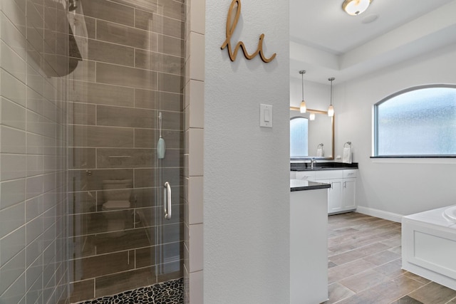 full bath with vanity, a shower stall, and baseboards