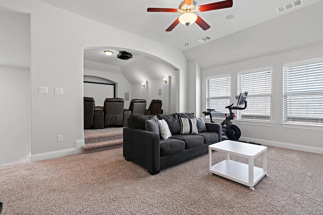 carpeted living room featuring baseboards, visible vents, arched walkways, ceiling fan, and vaulted ceiling