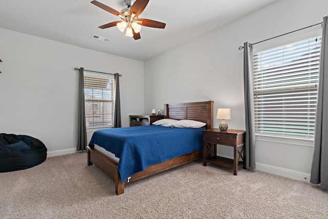 bedroom featuring ceiling fan, light colored carpet, visible vents, and baseboards