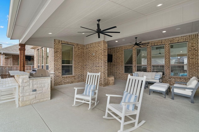 view of patio with an outdoor living space, area for grilling, and ceiling fan